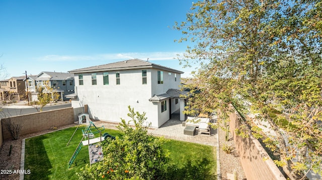 back of property with a yard, outdoor lounge area, and a patio