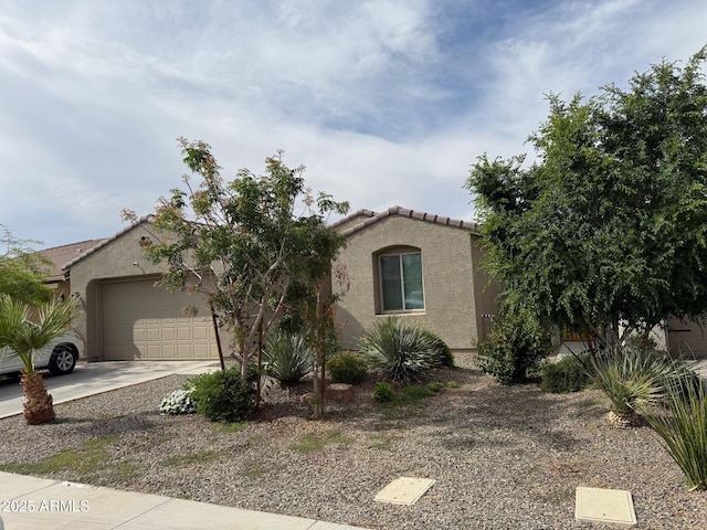 view of front of house featuring a garage, stucco siding, concrete driveway, and a tile roof
