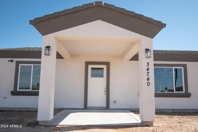 view of exterior entry featuring stucco siding