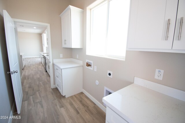 laundry room featuring washer hookup, light wood finished floors, cabinet space, hookup for an electric dryer, and baseboards