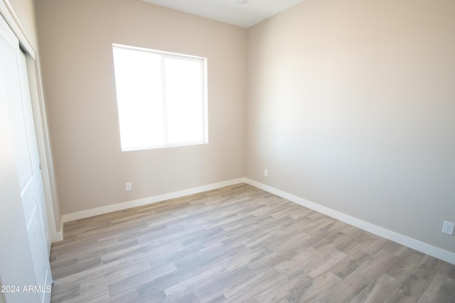 spare room featuring light wood-style flooring and baseboards