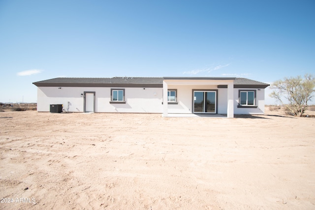 back of house featuring central AC and stucco siding