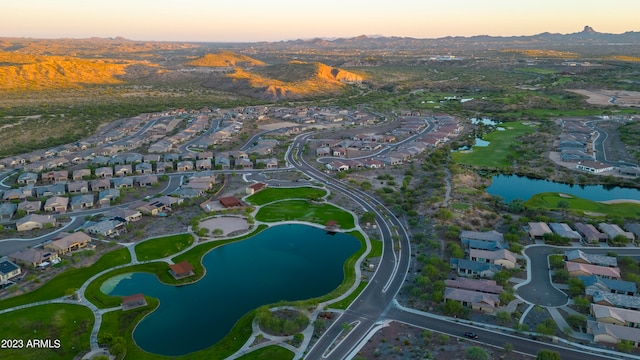 aerial view at dusk featuring a water view