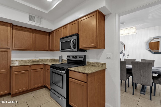 kitchen featuring light stone counters, light tile patterned floors, and appliances with stainless steel finishes