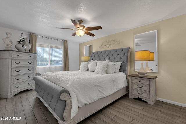 bedroom featuring a textured ceiling, light hardwood / wood-style floors, and ceiling fan