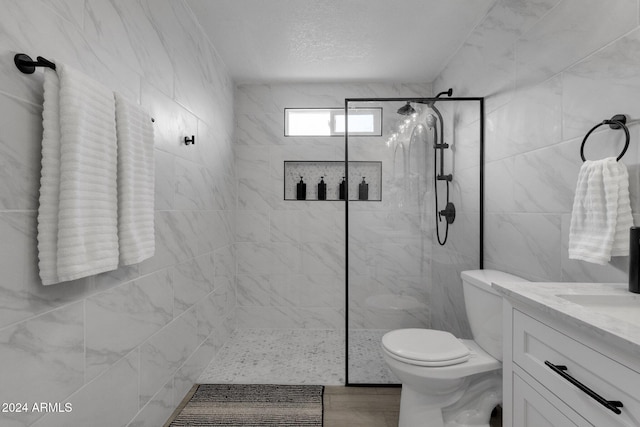 bathroom featuring toilet, vanity, and tiled shower