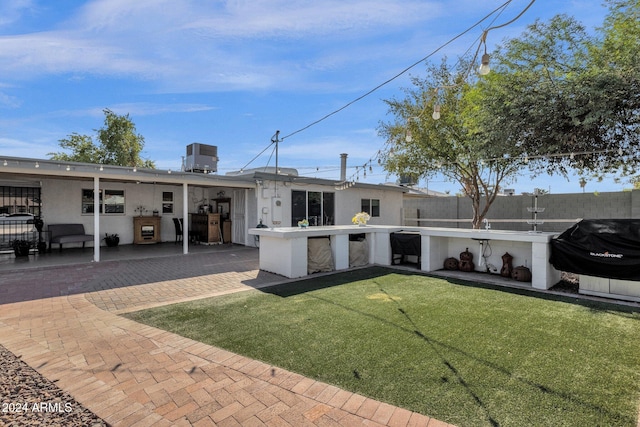 rear view of property with a yard and a patio