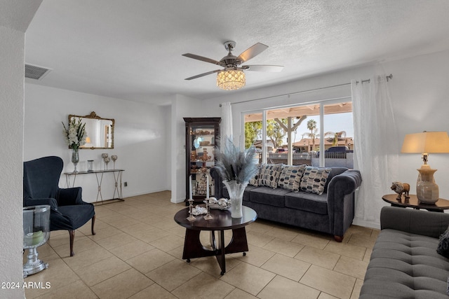 living room featuring light tile patterned floors, a textured ceiling, and ceiling fan