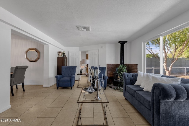 tiled living room with a wood stove and a textured ceiling