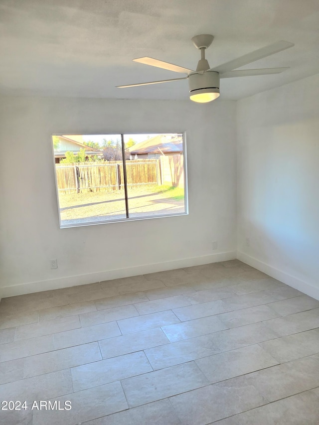 spare room featuring ceiling fan and a healthy amount of sunlight