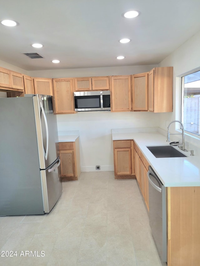 kitchen featuring light brown cabinets, sink, and stainless steel appliances