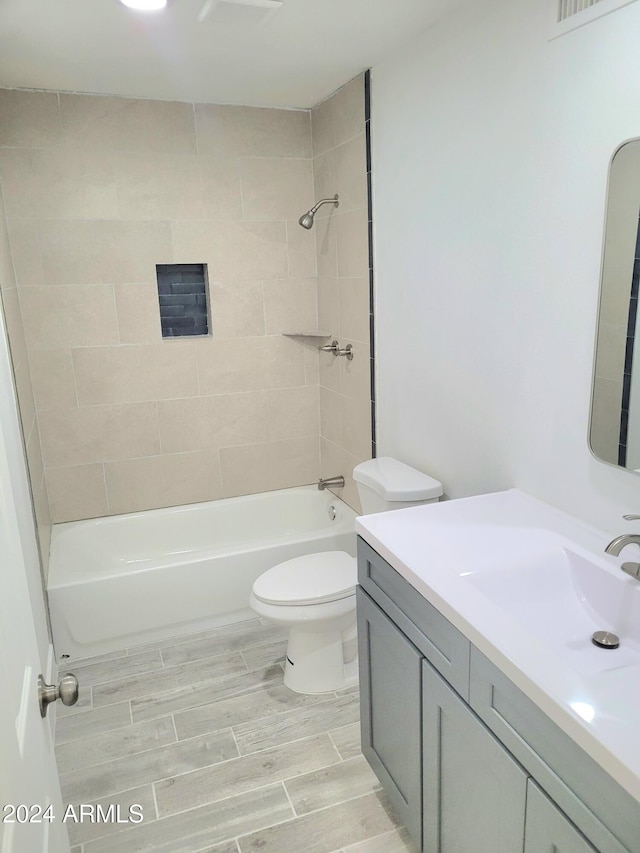 full bathroom featuring toilet, vanity, and tiled shower / bath