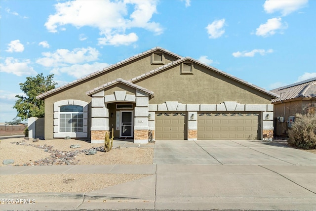 view of front of house with a garage, driveway, stone siding, and stucco siding