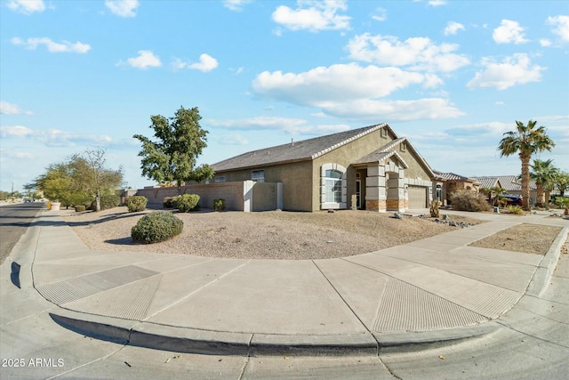 exterior space featuring a garage, a fenced front yard, and stucco siding