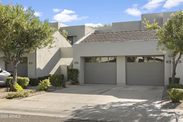 7700 E Gainey Ranch Rd Unit 206, Scottsdale, AZ 85258 - modern home with concrete driveway, an attached garage, and stucco siding