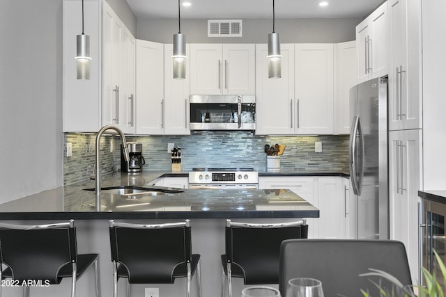 7700 E Gainey Ranch Rd Unit 206, Scottsdale, AZ 85258 - kitchen with stainless steel appliances, a sink, wine cooler, decorative backsplash, and recessed lighting