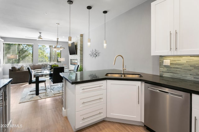 kitchen featuring dishwasher, sink, pendant lighting, light wood-type flooring, and white cabinetry