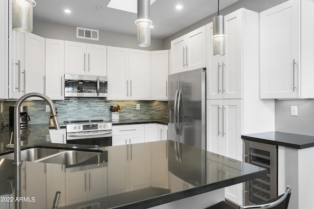 7700 E Gainey Ranch Rd Unit 206, Scottsdale, AZ 85258 - kitchen with stainless steel appliances, wine cooler, a sink, dark countertops, and recessed lighting