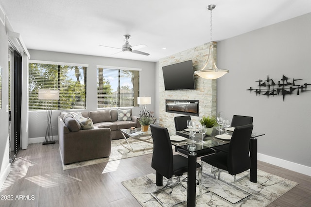 7700 E Gainey Ranch Rd Unit 206, Scottsdale, AZ 85258 - living area featuring a fireplace, baseboards, ceiling fan, and wood finished floors