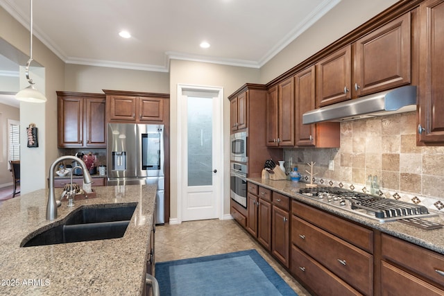 kitchen featuring light stone counters, stainless steel appliances, decorative backsplash, a sink, and under cabinet range hood