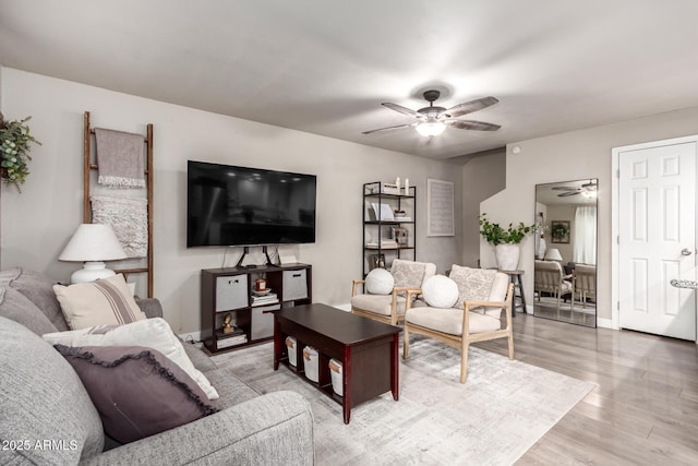 living room featuring wood-type flooring and ceiling fan