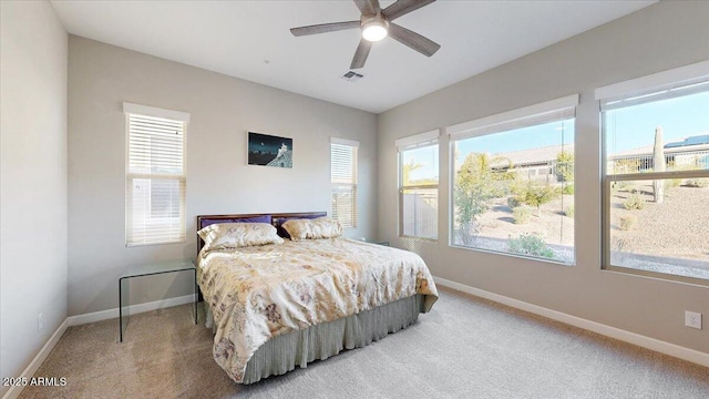 carpeted bedroom featuring ceiling fan and multiple windows