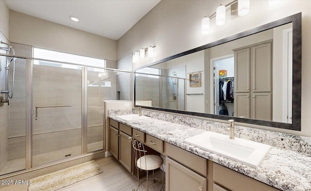 bathroom with a shower with door, vanity, and hardwood / wood-style flooring