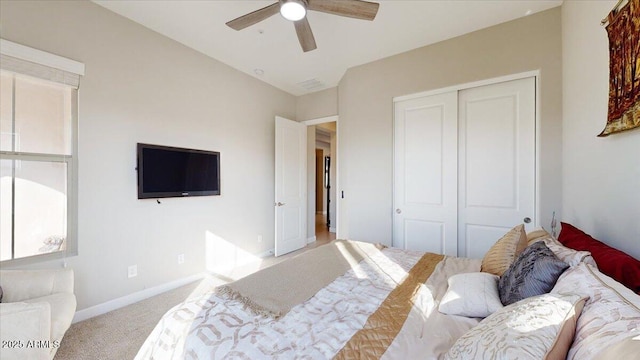 bedroom with lofted ceiling, light carpet, ceiling fan, and a closet