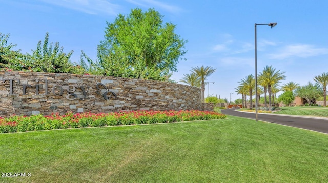 community / neighborhood sign featuring a yard