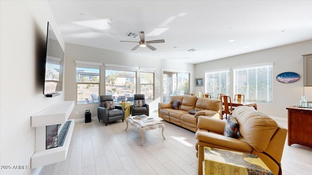 living room featuring ceiling fan and light hardwood / wood-style flooring