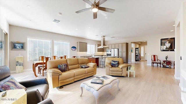 living room with light hardwood / wood-style flooring and ceiling fan