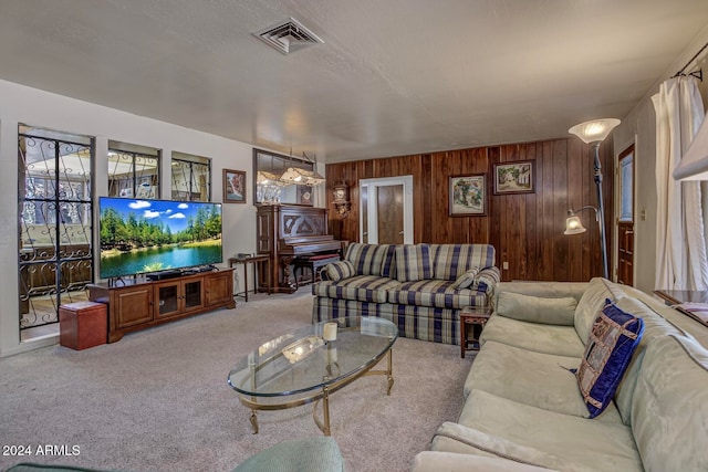 living room featuring wood walls and light colored carpet