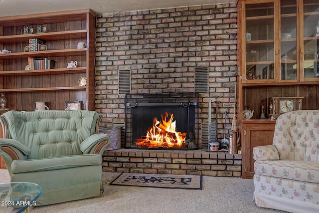 living room featuring carpet and a brick fireplace