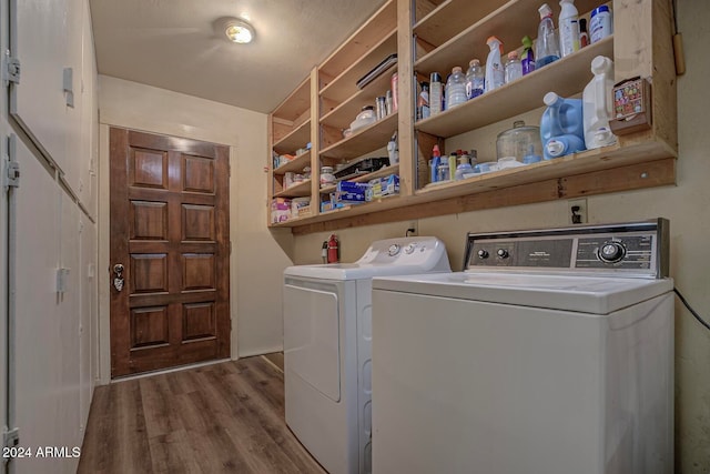 washroom with washer and clothes dryer and hardwood / wood-style floors