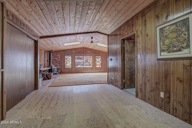 hall with wood walls, wooden ceiling, and lofted ceiling