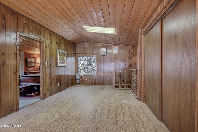 spare room with wood walls, wood ceiling, vaulted ceiling, and light wood-type flooring