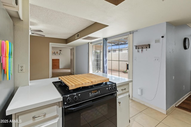 kitchen with visible vents, a textured ceiling, light countertops, black range with gas stovetop, and ceiling fan