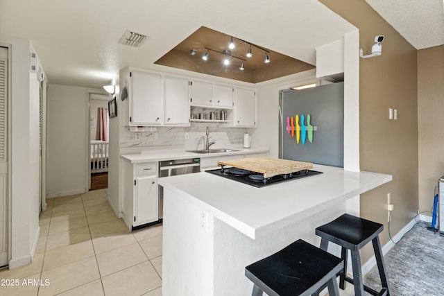 kitchen featuring light countertops, white cabinets, appliances with stainless steel finishes, and a sink