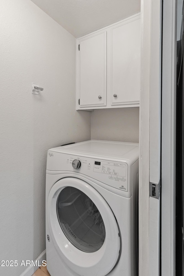 laundry area featuring cabinet space, washer / clothes dryer, and baseboards