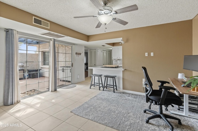 office featuring visible vents, a textured ceiling, ceiling fan, and light tile patterned flooring