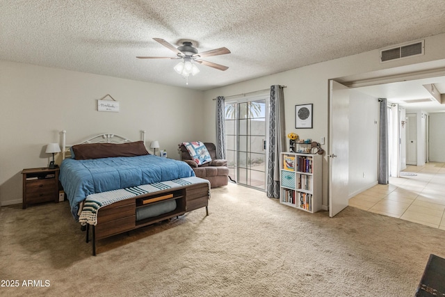 bedroom featuring visible vents, ceiling fan, carpet flooring, tile patterned floors, and a textured ceiling