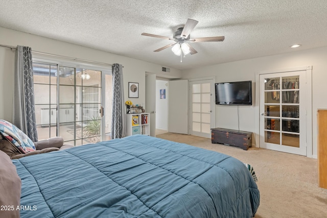 carpeted bedroom featuring access to outside, a ceiling fan, visible vents, and a textured ceiling