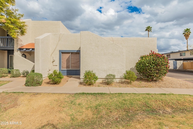 view of front of property featuring stucco siding and a front lawn