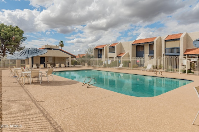 pool featuring a patio area, fence, and a residential view