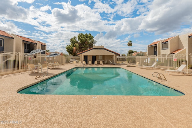 community pool featuring a residential view, fence, and a patio area