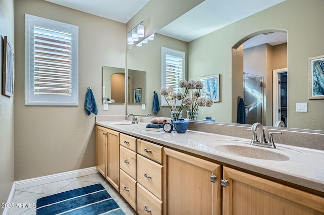 full bathroom with tile patterned flooring, a sink, baseboards, and double vanity