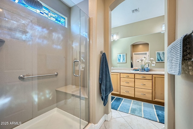 full bathroom with double vanity, a stall shower, visible vents, and tile patterned floors