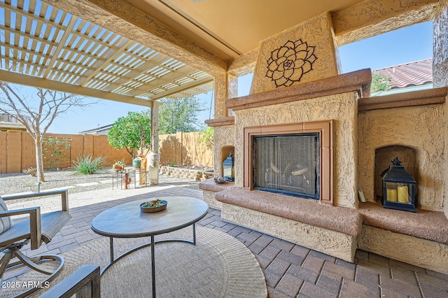 view of patio / terrace featuring exterior fireplace, a fenced backyard, and a pergola