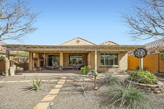 back of house with a tile roof, fence, a patio, and stucco siding