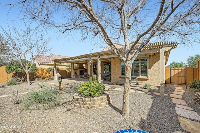 rear view of property with a patio, a gate, fence, a pergola, and stucco siding